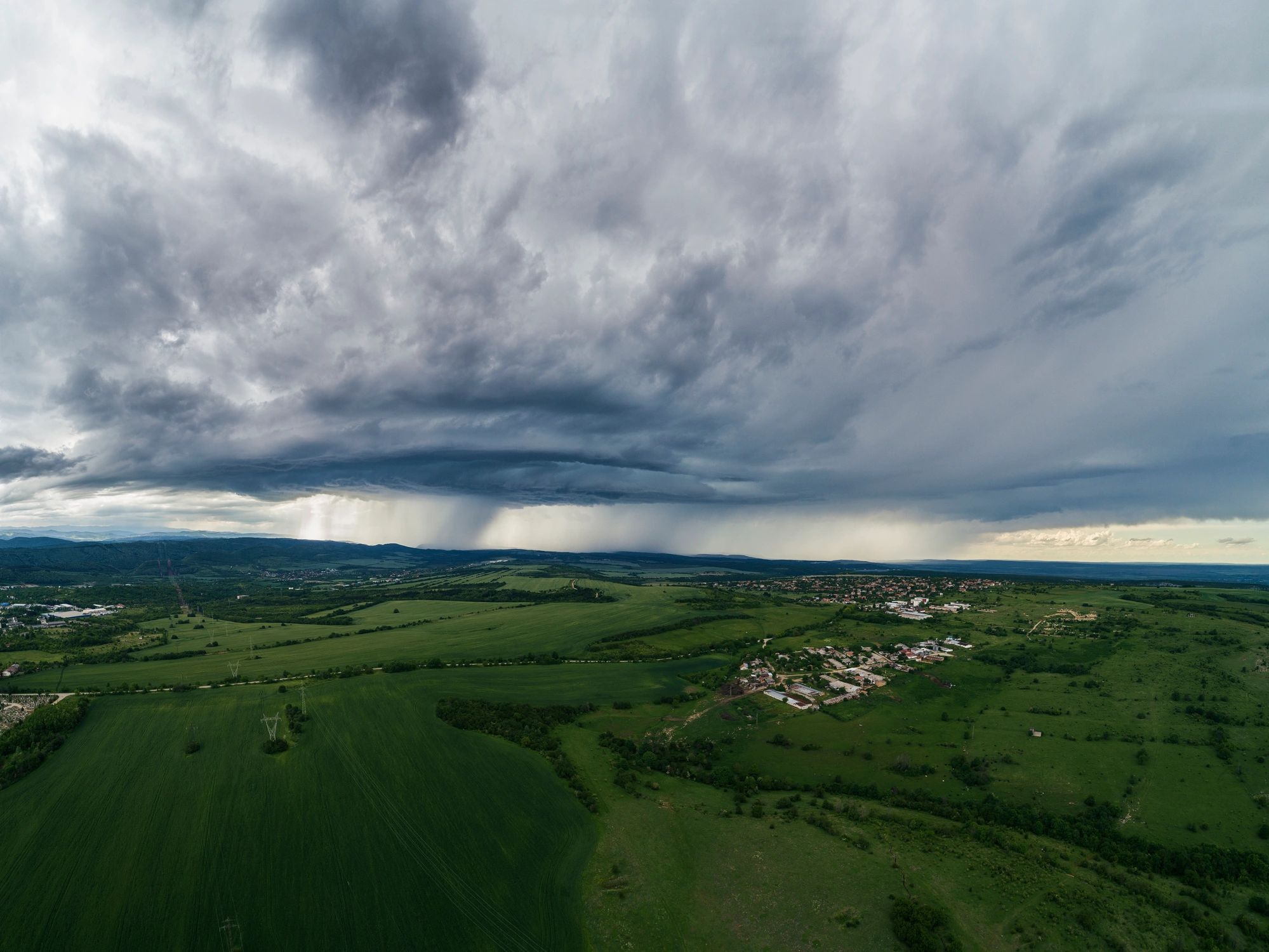 Aerial landscape beneath heavy rain clouds
