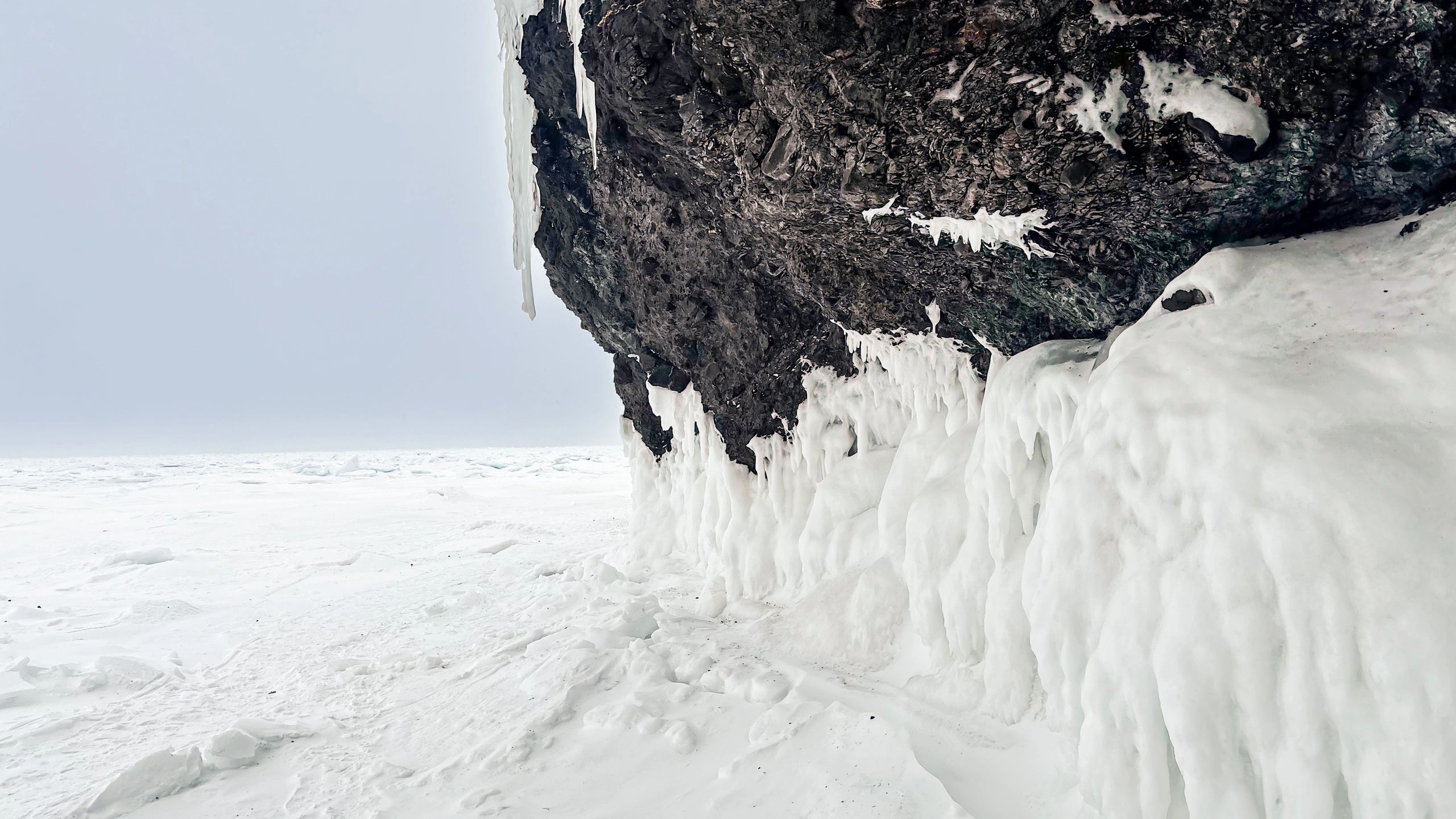 Frozen coastline with thick ice sheets above a packed icy shoreline