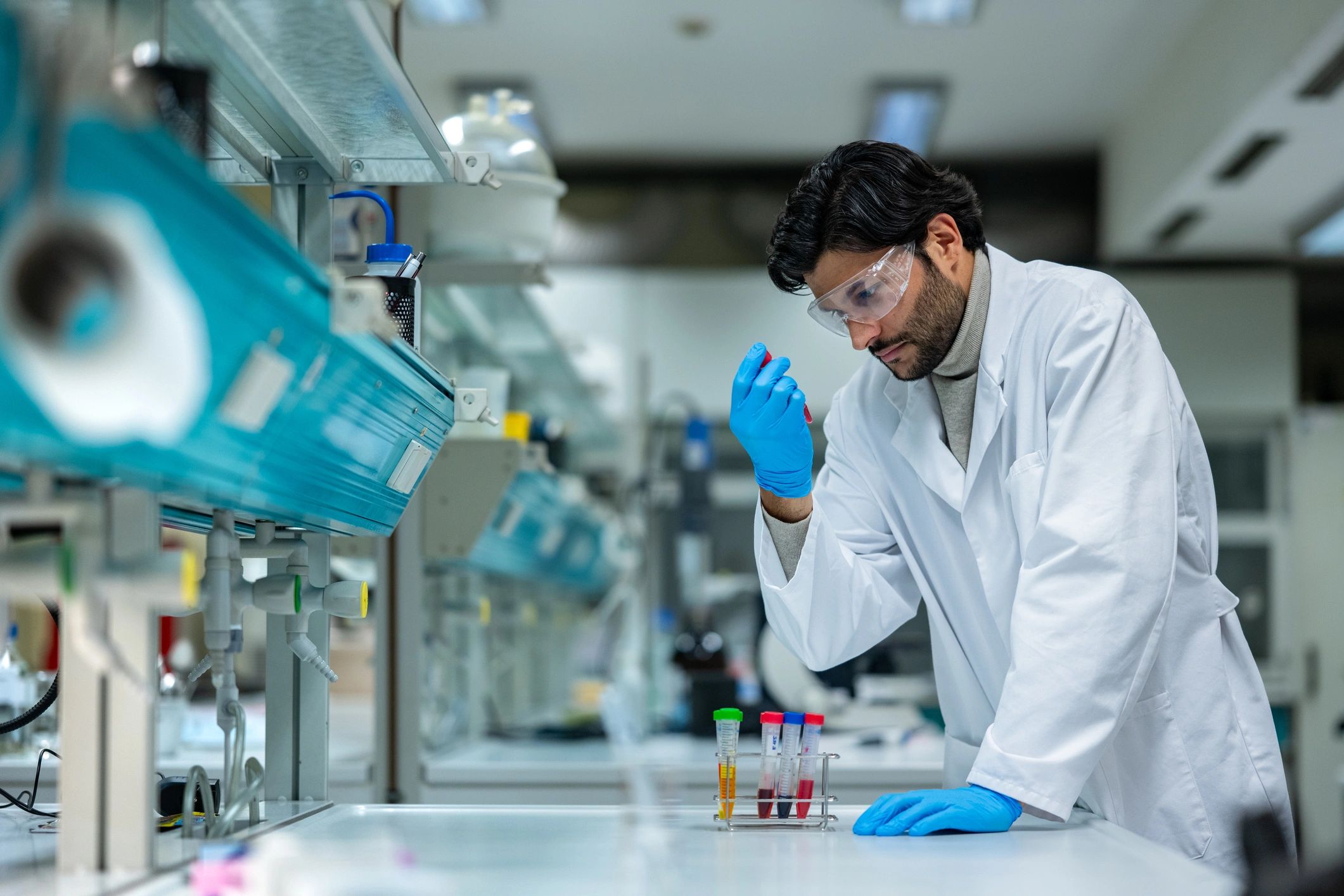 Scientist examining colorful liquids in a modern laboratory