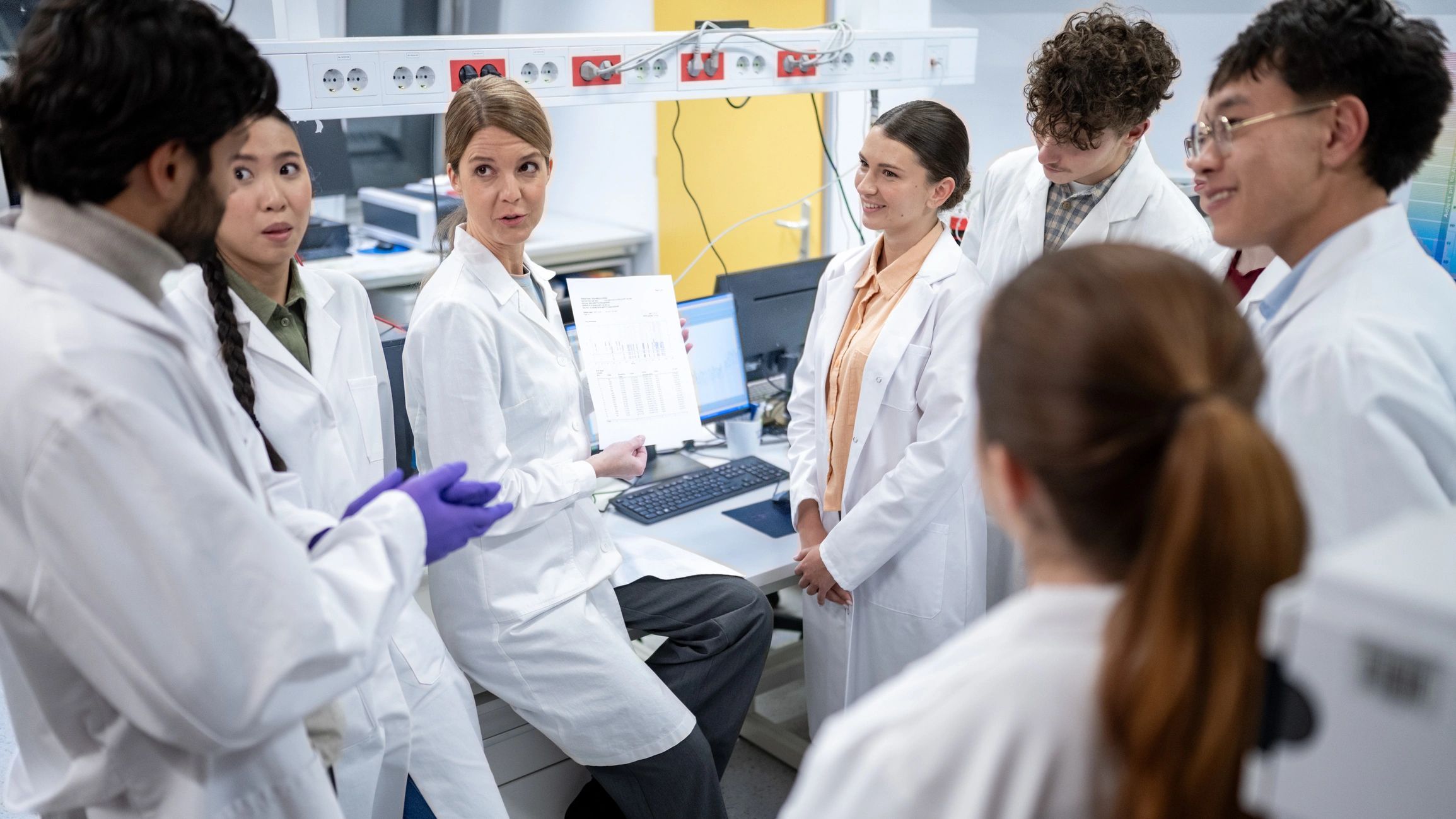 Diverse scientists discussing research in a bustling laboratory